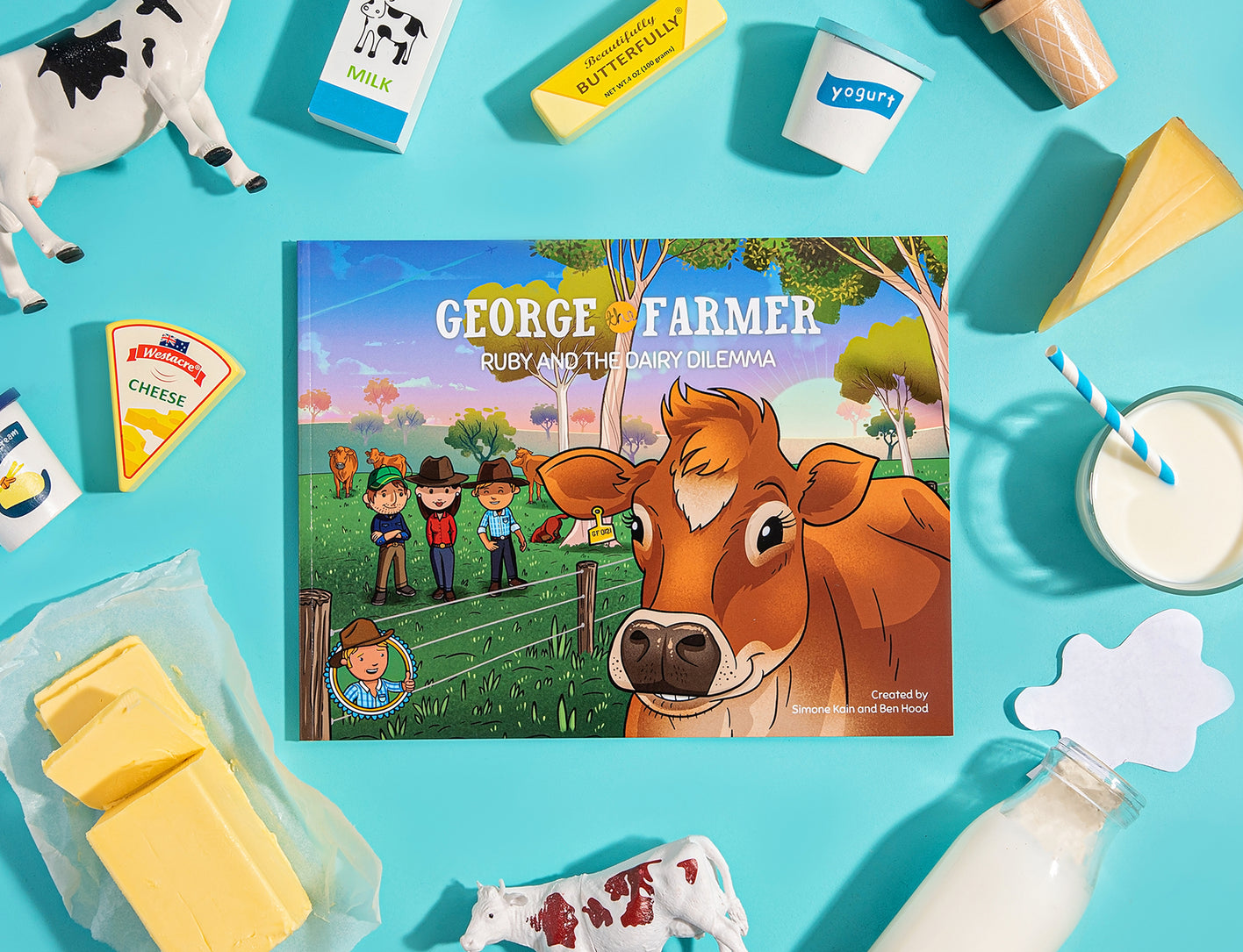 A children's picture book titled 'George the Farmer, Ruby and the Dairy Dilemma' displayed alongside dairy products like milk and cheese, and farm animal toys.